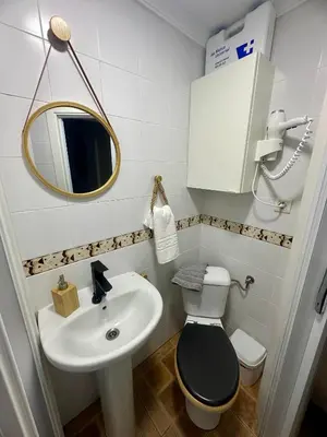 a bathroom with a sink and a toilet and a mirror at Encanto Jerezano Hideaway - Apartamento en Jerez - Apartment in Sherry in Jerez de la Frontera