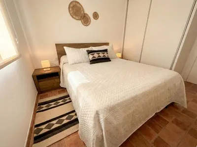 a small bedroom with a bed and a table at Encanto Jerezano Hideaway - Apartamento en Jerez - Apartment in Sherry in Jerez de la Frontera