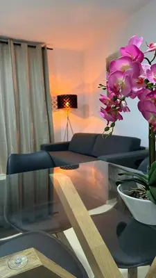 a living room with a glass table and purple flowers at Moderno y céntrico Apartamento de 2 dormitorios en El Puerto de Santa Maria in El Puerto de Santa María