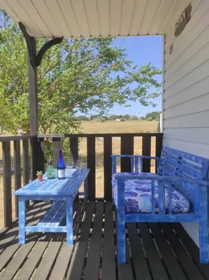 a blue table and a bench on a deck at Bungalow Mobilhome Agua en Chiclana de la Frontera, Cádiz in Chiclana de la Frontera