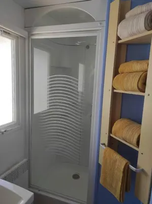a glass shower in a bathroom with towels at Bungalow Mobilhome Agua en Chiclana de la Frontera, Cádiz in Chiclana de la Frontera