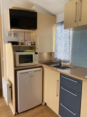 a small kitchen with a sink and a microwave at Bungalow Mobilhome Agua en Chiclana de la Frontera, Cádiz in Chiclana de la Frontera