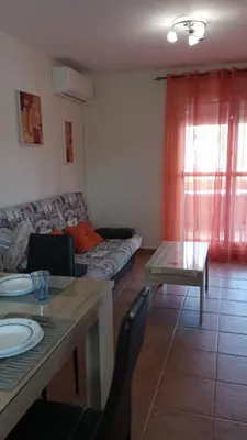 a living room with a couch and a table at Bonito y confortable apartamento Novo Sancti Petri Barrosa Chiclana Cadiz in Chiclana de la Frontera