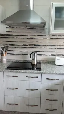a kitchen with white cabinets and a stove top at Bonito y confortable apartamento Novo Sancti Petri Barrosa Chiclana Cadiz in Chiclana de la Frontera