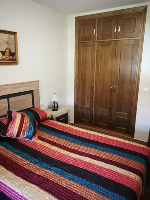 a bedroom with a bed with a colorful blanket on it at Bonito y confortable apartamento Novo Sancti Petri Barrosa Chiclana Cadiz in Chiclana de la Frontera