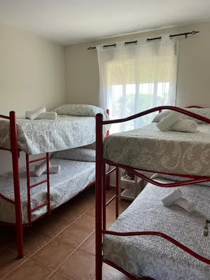 a room with three bunk beds and a window at Bonito y confortable apartamento Novo Sancti Petri Barrosa Chiclana Cadiz in Chiclana de la Frontera