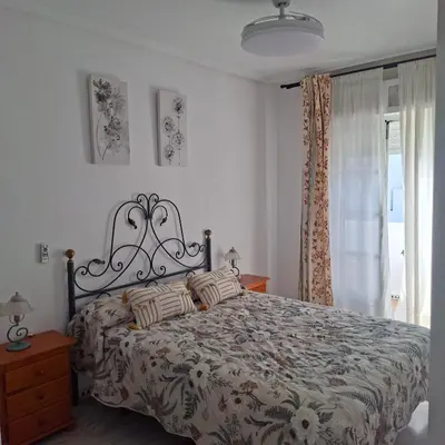 a bedroom with a bed and a window at Apartamento pinar del atlántico in Chiclana de la Frontera