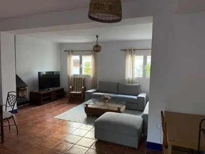 a living room with a couch and a tv at Adosado La Loma en Novo Sancti Petri in Chiclana de la Frontera