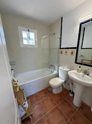 a bathroom with a tub and a toilet and a sink at Adosado La Loma en Novo Sancti Petri in Chiclana de la Frontera