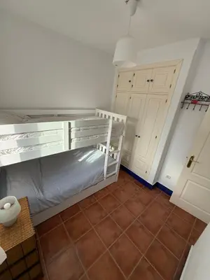 a small room with a bunk bed and a closet at Adosado La Loma en Novo Sancti Petri in Chiclana de la Frontera
