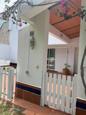 a house with a white gate and a fence at Adosado La Loma en Novo Sancti Petri in Chiclana de la Frontera