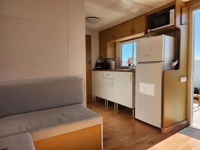 a small kitchen with a refrigerator and a table at Franceses in Chiclana de la Frontera