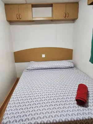 a bed in a small room with a red pillow on it at Franceses in Chiclana de la Frontera