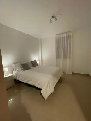 a white bedroom with a bed and a window at Disfruta Jerez in Jerez de la Frontera