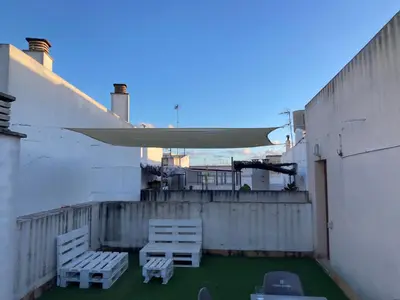 two white chairs and a table on a balcony at Disfruta Jerez in Jerez de la Frontera