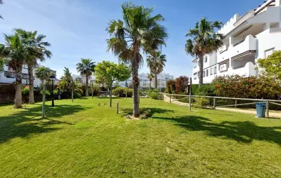 a park with palm trees in front of a building at Gorgeous Apartment In Rota With Wifi in Rota