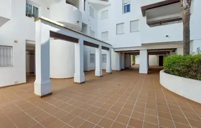 an empty courtyard of a white building with pillars at Gorgeous Apartment In Rota With Wifi in Rota