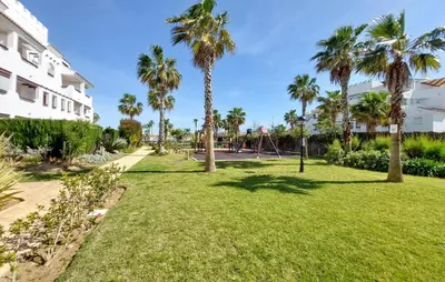 a park with palm trees next to a building at Gorgeous Apartment In Rota With Wifi in Rota
