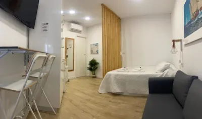 a small room with a bed and a chair in it at Coqueto Mini piso / Estudio/ 20 metros / playa / Wifi in Chiclana de la Frontera