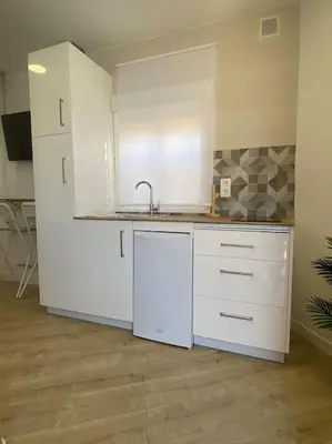 a kitchen with white cabinets and a sink at Coqueto Mini piso / Estudio/ 20 metros / playa / Wifi in Chiclana de la Frontera