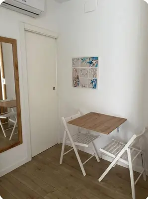 a table and chairs in a room with a mirror at Coqueto Mini piso / Estudio/ 20 metros / playa / Wifi in Chiclana de la Frontera