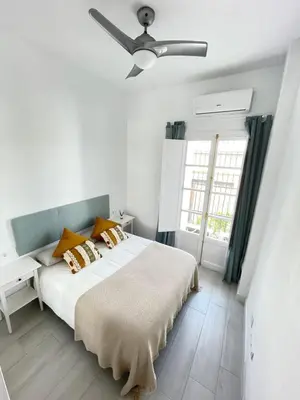 a bedroom with a bed with a ceiling fan at Dublin apartment in El Puerto in El Puerto de Santa María