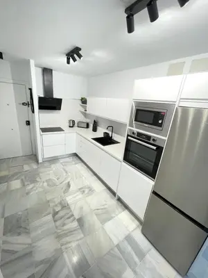 a white kitchen with a sink and a refrigerator at Dublin apartment in El Puerto in El Puerto de Santa María