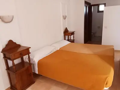 a bedroom with a bed and a wooden nightstand at Apartamentos Jasmund - Estudio 02 in San Fernando