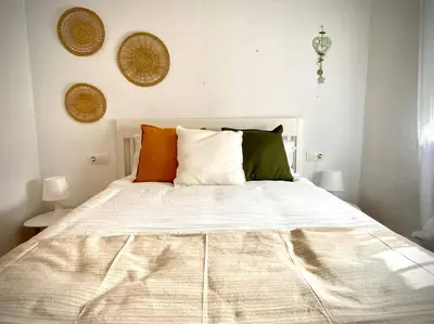 a bedroom with a large white bed with pillows at MyChoice Casa Lilia in Rota