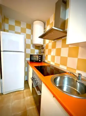 a kitchen with a sink and a white refrigerator at MyChoice Casa Lilia in Rota