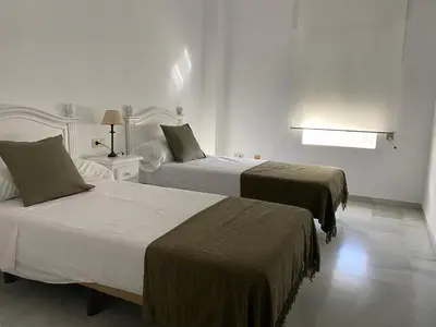 a hotel room with two beds and a window at Jerez Avenida in Jerez de la Frontera