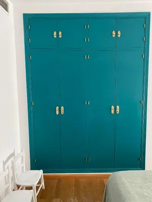 a blue cabinet in a bedroom with two white chairs at Jerez Avenida in Jerez de la Frontera