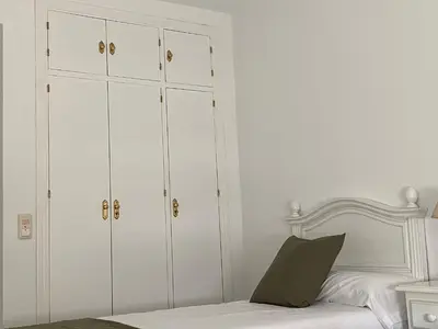 a bedroom with white cabinets and a bed at Jerez Avenida in Jerez de la Frontera