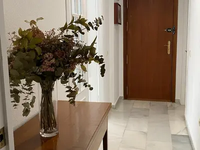 a vase of flowers on a table in a hallway at Jerez Avenida in Jerez de la Frontera