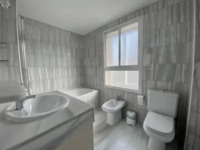 a bathroom with a sink and a toilet and a window at Jerez Avenida in Jerez de la Frontera