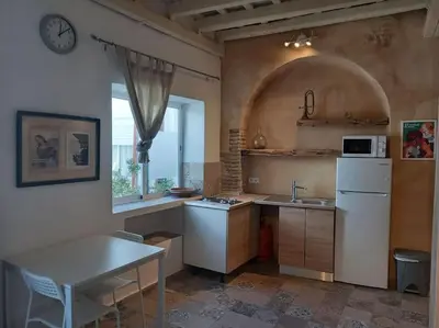 a kitchen with a white refrigerator and a table at Casa Florinda #5 in Jerez de la Frontera
