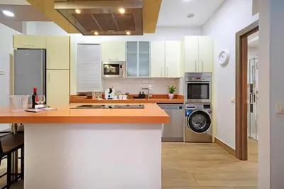 a kitchen with white cabinets and a washer and dryer at Apartamento Casa Pili in El Puerto de Santa María