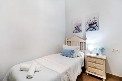 a small bedroom with a bed and a nightstand at Apartamento Casa Pili in El Puerto de Santa María