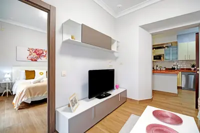 a living room with a television and a bedroom at Apartamento Casa Pili in El Puerto de Santa María