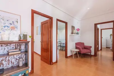 a living room with a red chair and a mirror at Cadizz - Villa Verde- La Barrosa - ideal familias y grupos de amigos in Chiclana de la Frontera