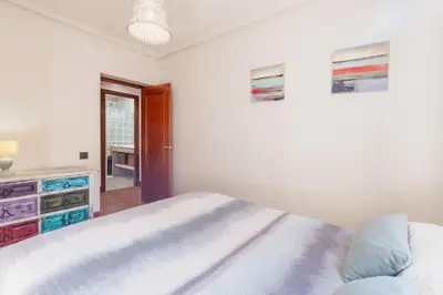 a white bedroom with a bed and a dresser at Cadizz - Villa Verde- La Barrosa - ideal familias y grupos de amigos in Chiclana de la Frontera