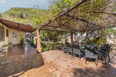 a patio with a table and chairs under a pergola at Cadizz - Villa Verde- La Barrosa - ideal familias y grupos de amigos in Chiclana de la Frontera