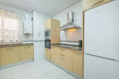 a kitchen with wooden cabinets and a stove top oven at El Pez Volador by Gades Gestión in Cádiz