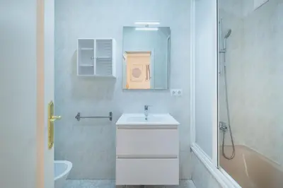 a white bathroom with a sink and a shower at El Pez Volador by Gades Gestión in Cádiz