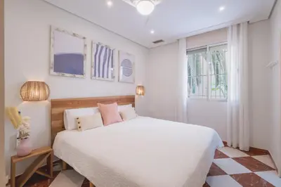 a bedroom with a white bed with pink pillows at El Pez Volador by Gades Gestión in Cádiz