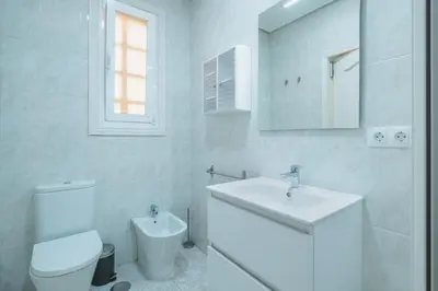 a white bathroom with a toilet and a sink at El Pez Volador by Gades Gestión in Cádiz