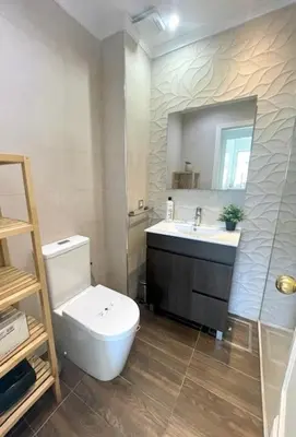 a bathroom with a toilet and a sink and a mirror at GATU SIROCO junto la playa, piscina, aire acc, terraza, 