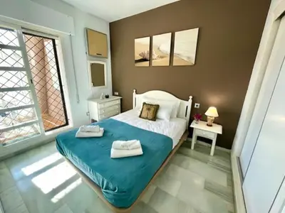 a bedroom with a bed with two towels on it at GATU SIROCO junto la playa, piscina, aire acc, terraza, 