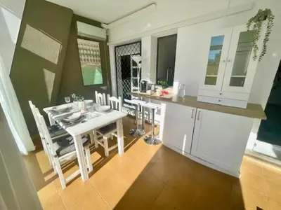 a kitchen and dining room with a table and chairs at GATU SIROCO junto la playa, piscina, aire acc, terraza, 