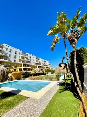 a resort with a swimming pool and palm trees at GATU SIROCO junto la playa, piscina, aire acc, terraza, 
